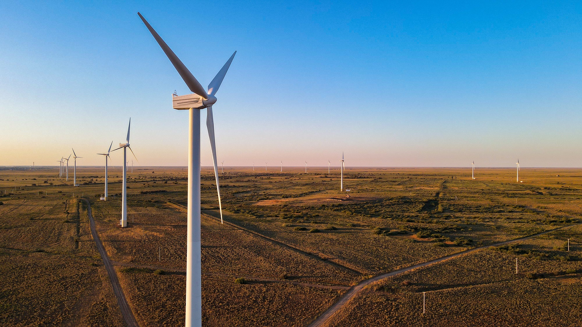 Wind turbines across the Kazakh steppe at golden hour