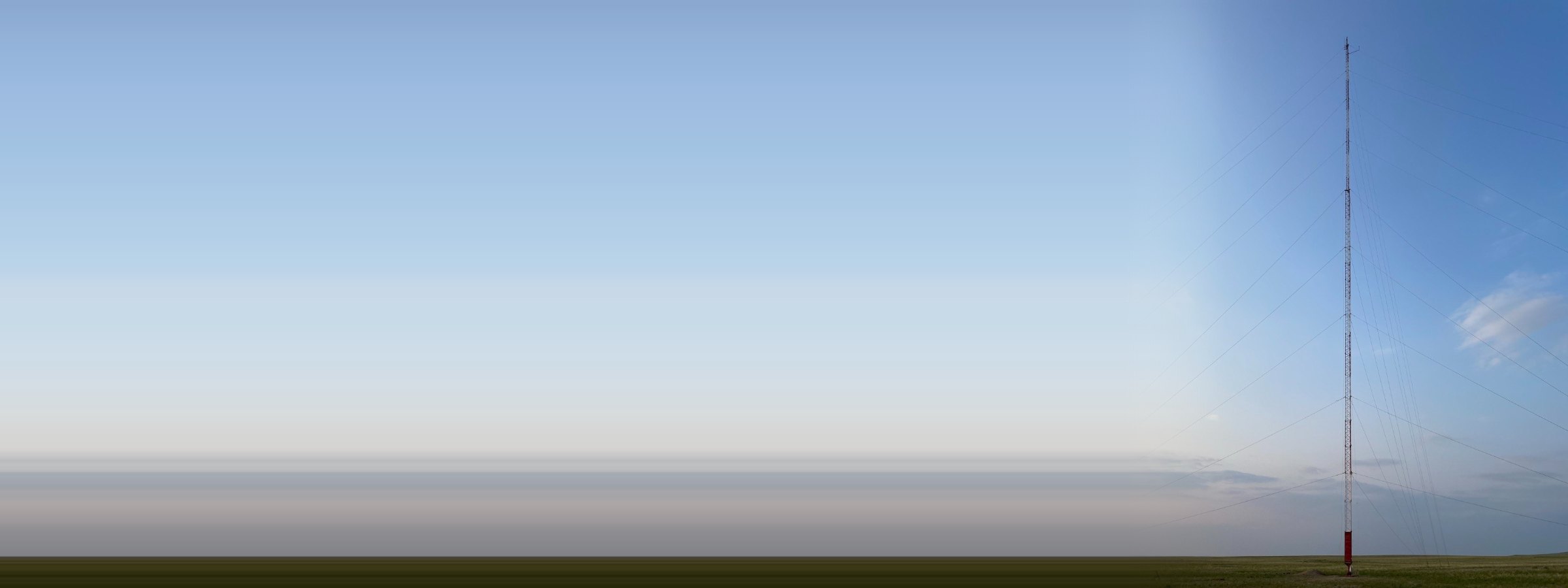 A 140 m guyed met mast standing in open Central Asian steppe under a clear sky